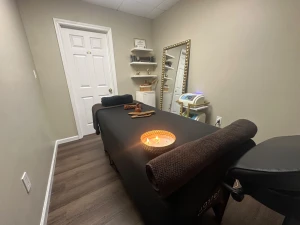 Treatment room with warm lighting and a prepared massage table