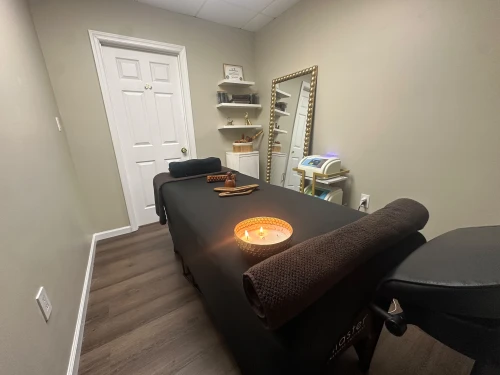 Private wellness room with a massage table and wooden details